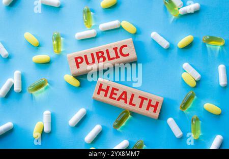 Simbolo di sanità pubblica. Concetto di salute pubblica su blocchi di legno. Bellissimo sfondo blu con pillole. Medicina e salute pubblica. Copia spac Foto Stock