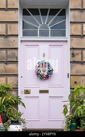 Porta rosa dipinta con pannelli frontali in stile georgiano con corona di Natale, Drummond Place, Edinburgh New Town, Scotland, UK Foto Stock