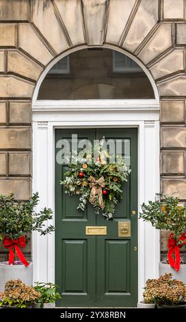 Porta verde dipinta con pannelli frontali in stile georgiano con fanlight e corona di Natale, Edinburgh New Town, Scozia, Regno Unito Foto Stock