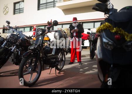 Malaga, Spagna. 14 dicembre 2024. Un uomo vestito da "Babbo Natale" viene visto controllare il suo cellulare prima di prendere parte all'X Toy Run Torremolinos. Centinaia di motociclisti e motociclisti si incontrano ogni anno nel centro di Torremolinos per partecipare a una gara di beneficenza vestita con costumi di Babbo Natale e collezionando giocattoli per bambini. Credito: SOPA Images Limited/Alamy Live News Foto Stock