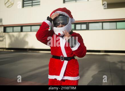 Malaga, Spagna. 14 dicembre 2024. Una donna vestita da "Mrs. Claus" viene vista indossare un casco da moto prima di prendere parte all'X Toy Run Torremolinos. Centinaia di motociclisti e motociclisti si incontrano ogni anno nel centro di Torremolinos per partecipare a una gara di beneficenza vestita con costumi di Babbo Natale e collezionando giocattoli per bambini. Credito: SOPA Images Limited/Alamy Live News Foto Stock