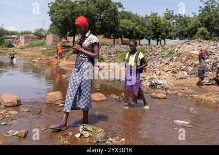 Le studentesse africane devono attraversare strade sterrate allagate per andare a scuola. Condizioni meteorologiche estreme nella regione del Sahel a causa dei cambiamenti climatici Foto Stock