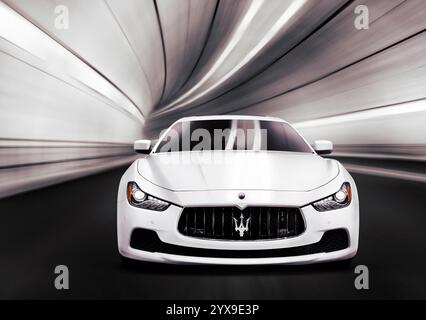 White 2014 Maserati Ghibli S Q4 auto di lusso accelerando in un tunnel. Vista frontale. Foto Stock