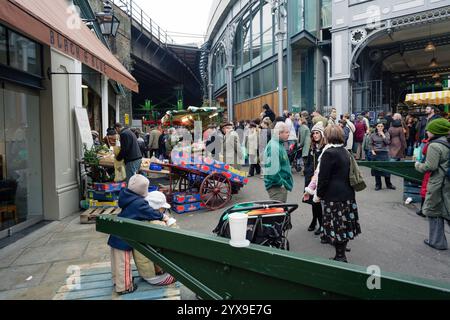 Gli amanti dello shopping in un momento affollato prima di Natale al Borough Market di Londra, Regno Unito. Foto Stock