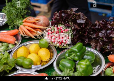 Frutta e verdura, compresi limoni, limes, peperoni verdi, carote e ravanelli in vendita al Borough Market di Londra, Regno Unito Foto Stock