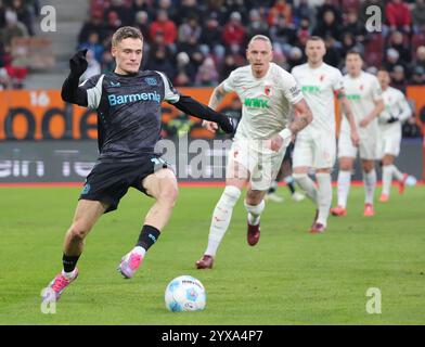 Augusta, Germania. 14 dicembre 2024. Florian Wirtz (L) del Bayer 04 Leverkusen compete durante la partita di calcio tedesca di prima divisione della Bundesliga tra l'Augsburg e il Bayer 04 Leverkusen ad Augusta, Germania, 14 dicembre 2024. Crediti: Philippe Ruiz/Xinhua/Alamy Live News Foto Stock