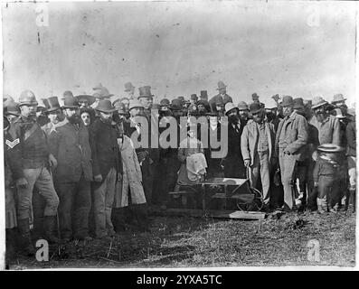 Gruppo allo scavo del primo vascello per la Main Trunk Railway. Si trovarono alla linea di confisca sulla riva meridionale del fiume Puniu, il 15 aprile 1885. Al centro dietro la barrow, con indosso un cappello, c'è Rewi Maniapoto. Subito alla sua sinistra c'è sua figlia, te Kore. Alla sua sinistra e dietro c'è Sir Robert Stout. L'uomo alto che indossa un cappello, in piedi a sinistra di Stout, è Wahanui Huatare. La fotografia originale è stata scattata da Daniel Manders Beere Foto Stock