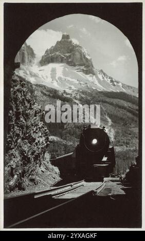 Cartolina d'epoca in bianco e nero che mostra la locomotiva a vapore CPR che si avvicina al tunnel presso Cathedral Peak, Yoho National Park, British Columbia, Canada. Byron Harmon, fotografo, prima del 1942, cartolina Foto Stock