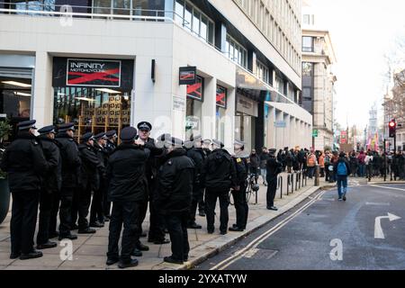 Londra, Regno Unito. 14 dicembre 2024. Gli agenti di polizia monitorano i sostenitori della London Renters Union che protestano al di fuori di una filiale dell'agente immobiliare Foxtons per chiedere controlli sugli affitti in tutto il Regno Unito. Secondo Zoopla, gli affitti sono aumentati del 27% nel Regno Unito dalla fine della pandemia di Covid-19 e ora stanno aumentando più rapidamente nelle aree più economiche. Crediti: Mark Kerrison/Alamy Live News Foto Stock