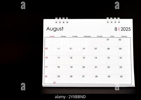 Calendario della scrivania per agosto 2025. Calendario desktop su sfondo nero. Foto Stock