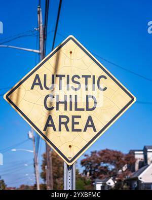 Harbor Isle, New York, Stati Uniti d'America – 23 ottobre 2024: Primo piano di un cartello giallo a forma di diamante con la scritta Autistic Child area. Foto Stock