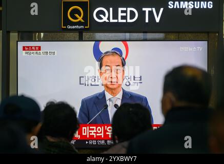 Seoul, Corea del Sud. 15 dicembre 2024. Una trasmissione televisiva Yonhapnews 24 ore su 24 alla stazione ferroviaria di Yongsan che mostra il presidente in carica Han Duck-soo che fa una dichiarazione pubblica. L'Assemblea nazionale della Corea del Sud votò per implorare il presidente Yoon Suk Yeol per la sua imposizione della legge marziale, sospendendolo dai suoi doveri fino a quando la Corte costituzionale non deciderà se reintegrarlo o rimuoverlo dall'incarico. Credito: SOPA Images Limited/Alamy Live News Foto Stock