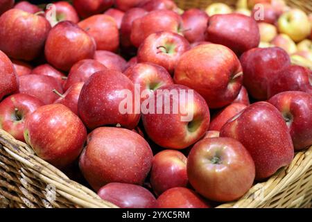 Mele rosse in un cestello di vimini. Raccolto fresco, frutta matura in un supermercato Foto Stock