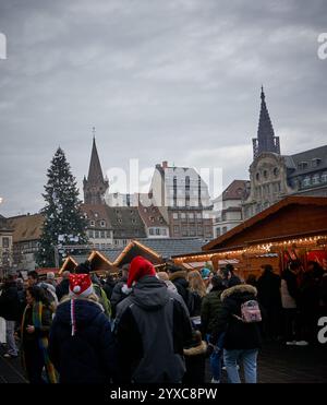 Strasburgo, Francia - 14 dicembre 2024: Veduta del mercato di Natale più antico del mondo con gente che fa shopping e acquista regali tradizionali. Foto Stock