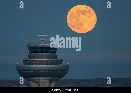 Madrid, Spagna. 15 dicembre 2024. La luna piena di dicembre nota come la luna fredda sorge sulla torre di controllo dell'aeroporto Adolfo Suarez Madrid Barajas, essendo l'ultima luna piena del 2024. Crediti: Marcos del Mazo/Alamy Live News Foto Stock