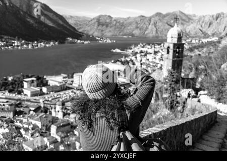 Cattaro, Montenegro - 14 febbraio 2024: Visitatore dai capelli ricci che scatta foto panoramiche della baia di Cattaro dal castello di Cattaro. Foto Stock