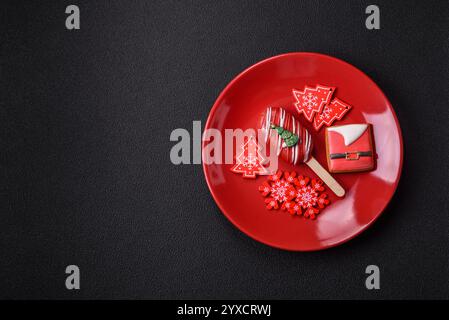 Gelato naturale a base di papaveri su un bastoncino ricoperto di cioccolato nello stile e nei colori di Natale e Capodanno su uno sfondo di cemento scuro Foto Stock