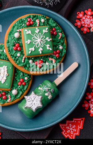 Gelato naturale a base di papaveri su un bastoncino ricoperto di cioccolato nello stile e nei colori di Natale e Capodanno su uno sfondo di cemento scuro Foto Stock