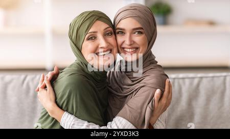 Madre allegra del Medio Oriente e figlia dell'adulto che abbraccia a casa Foto Stock