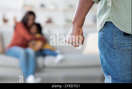 Violenza domestica. African American Man minaccia moglie e figlia con il suo pugno Foto Stock