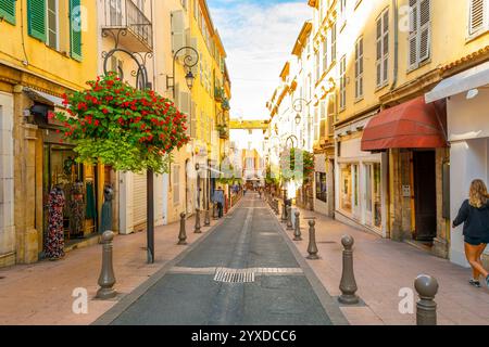 Una tipica e pittoresca strada di negozi, caffetterie e appartamenti ad Antibes, in Francia, sulla Costa Azzurra del Mar Mediterraneo. Foto Stock