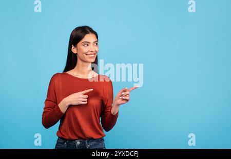 Bruna donna sorridente e gestante su sfondo blu Foto Stock