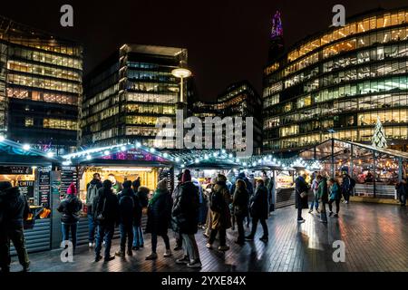 Le persone visitano il mercatino di Natale annuale "Winter by the River", vicino al Tower Bridge, Londra, Regno Unito. Foto Stock