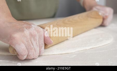 Mani che modellano l'impasto in palla a mano. Lo chef prepara l'impasto per cuocere il pane per pizza nel ristorante, cuocere. Foto Stock