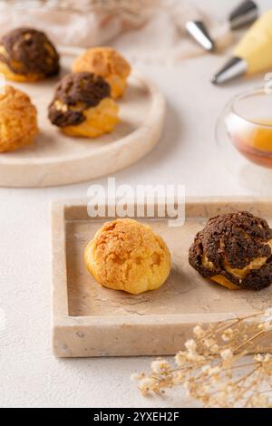 La pasta choux è un impasto delicato utilizzato in molti dolci. Contiene solo burro, acqua, farina e uova. A volte i dolci choux sono pieni di wi-fi Foto Stock