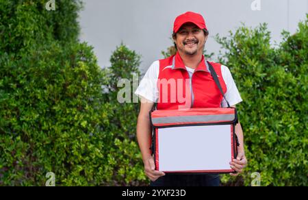 Addetto alla consegna con sacchetto termico rosso. Servizio di consegna di cibo veloce e conveniente durante un'epidemia di malattia virale. Uomo che consegna cibo ai clienti. Foto Stock