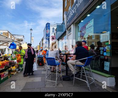 Londra - 06 17 2022: Persone sedute al caffè e altri negozi su Portobello Road Foto Stock
