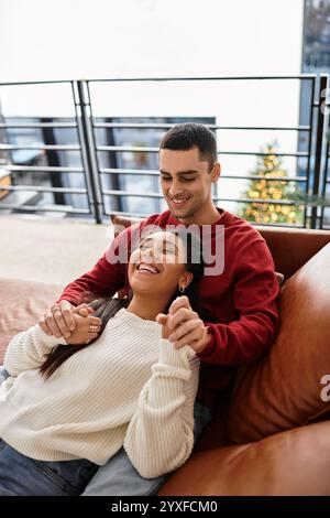 Una coppia si diverte a vicenda, abbracciando calore e amore in un intimo abbigliamento invernale. Foto Stock