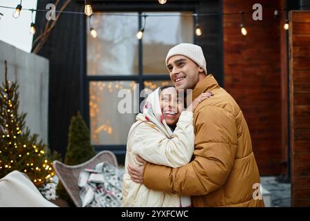 Una bella coppia condivide momenti caldi insieme tra le decorazioni natalizie. Foto Stock