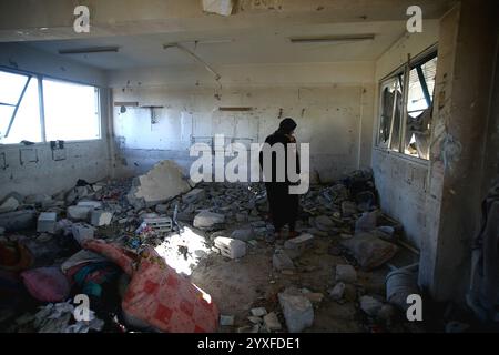 Khan Yunis, Palestina. 16 dicembre 2024. I palestinesi ispezionano i danni causati da un attacco dell'esercito israeliano a una scuola che ospita famiglie sfollate appartenenti all'Agenzia delle Nazioni Unite per il soccorso e l'occupazione dei rifugiati palestinesi nel vicino Oriente (UNRWA) a Khan Yunis, Gaza, Striscia di Gaza, territorio palestinese, il 16 dicembre, 2024. foto di Ramez Habboub/ABACAPRESS. COM credito: Abaca Press/Alamy Live News Foto Stock