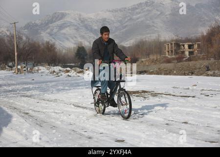 Kabul, Afghanistan. 16 dicembre 2024. Un ragazzo va in bicicletta nel distretto di Paghman, Kabul, capitale dell'Afghanistan, 16 dicembre 2024. Crediti: Saifurahman Safi/Xinhua/Alamy Live News Foto Stock