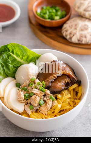 Cuocere. Gli spaghetti vengono gettati in aceto, carne macinata, fette di maiale, fegato di maiale, funghi tagliati in umido, polpette di carne e pezzetti di lardo fritto Foto Stock