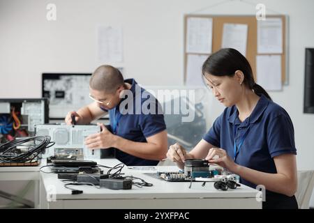 Collaborazione alla riparazione di componenti elettronici in Modern Workspace Foto Stock