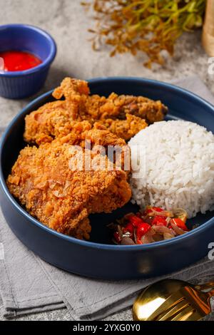 Ayam Geprek è un pollo fritto croccante con salsa di peperoncino sambal calda e piccante. Foto Stock