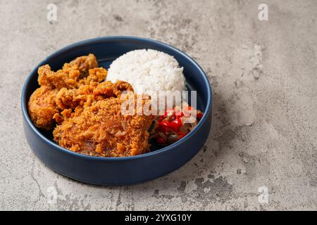Ayam Geprek è un pollo fritto croccante con salsa di peperoncino sambal calda e piccante. Foto Stock