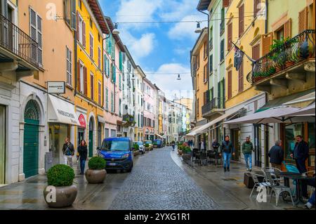 Brescia, Italia. Edificio tradizionale colorato con balconi, finestre a serrande e pareti multicolore in tipica strada italiana Foto Stock