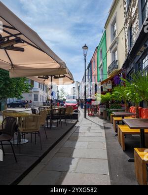 Londra - 06 17 2022: Ristorante all'aperto e case colorate in Portobello Rd Foto Stock