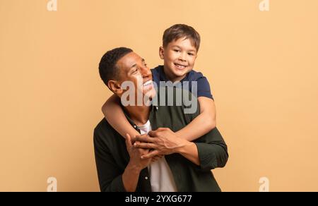 Padre e figlio condividono un momento di gioia con sorrisi e amore in un ambiente caldo Foto Stock