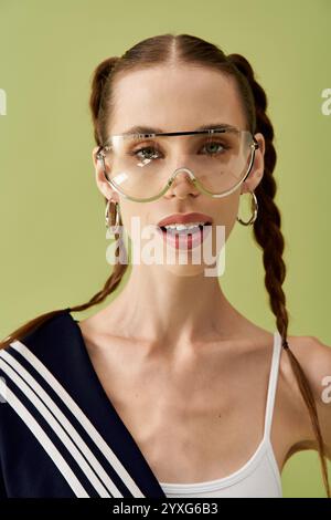 Una giovane donna mostra con fiducia il suo stile unico con capelli intrecciati e occhiali di tendenza. Foto Stock