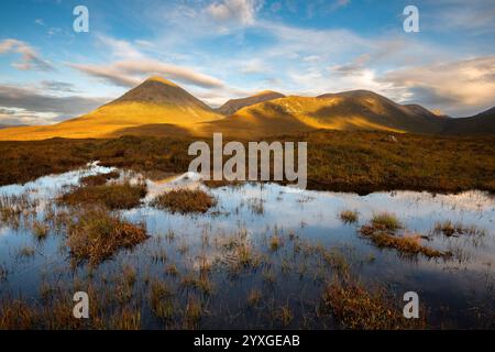 Montagne rosse di Cuillin coperte di luce dorata viste da Sligachan. Isola di Skye, Scozia, Regno Unito. Foto Stock