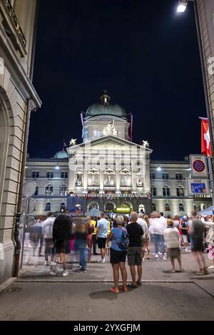 La splendida Bundeshaus illuminata dall'edificio del Parlamento o dal Palazzo Federale e una strada con gente di notte nella città di Berna, Cantone di Berna, Svizzera. Foto Stock