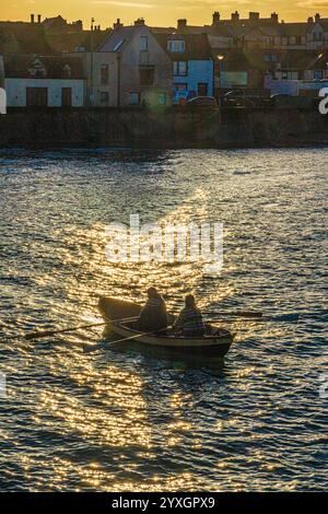 Una coppia di mezza età che regna su una piccola barca la domenica pomeriggio nel porto di Eyemouth, Berwickshire, Scottish Borders, Scozia, Regno Unito Foto Stock