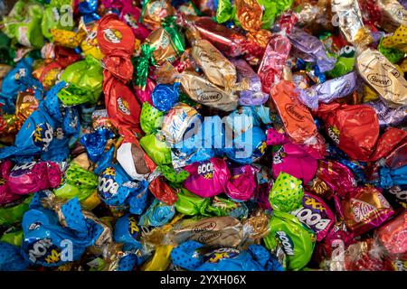 Un mucchio di caramelle dolci con confezioni colorate e impacchi. Foto Stock