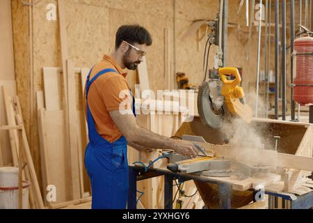 Carpentiere esperto che sega tavole di legno utilizzando una sega circolare rotonda sul banco di lavoro Foto Stock