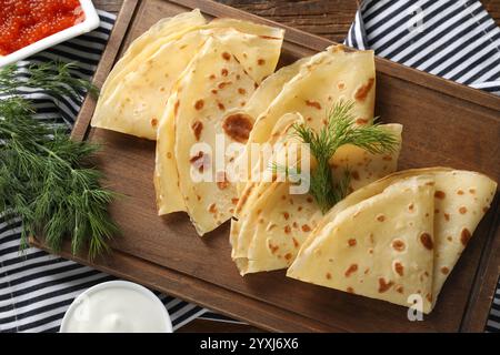 Deliziose crepe, aneto, caviale rosso e panna acida sul tavolo, piatti Foto Stock