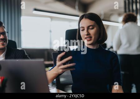 Un gruppo eterogeneo di dipendenti aziendali impegnati in un lavoro collaborativo utilizzando la tecnologia in un ambiente di ufficio moderno. Foto Stock